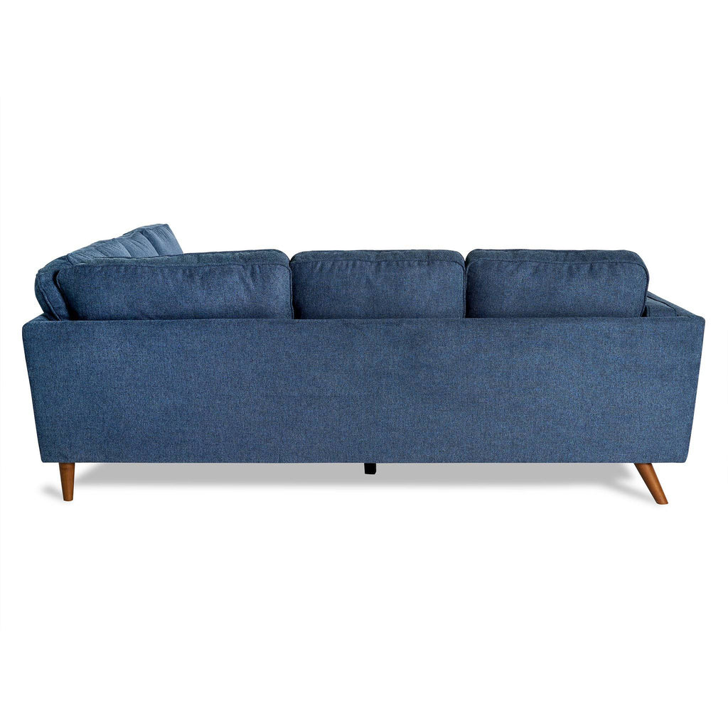 The living room features the Maddox sectional, a mid-century modern piece with three back cushions and angled wooden legs, all in blue and set against a white backdrop.