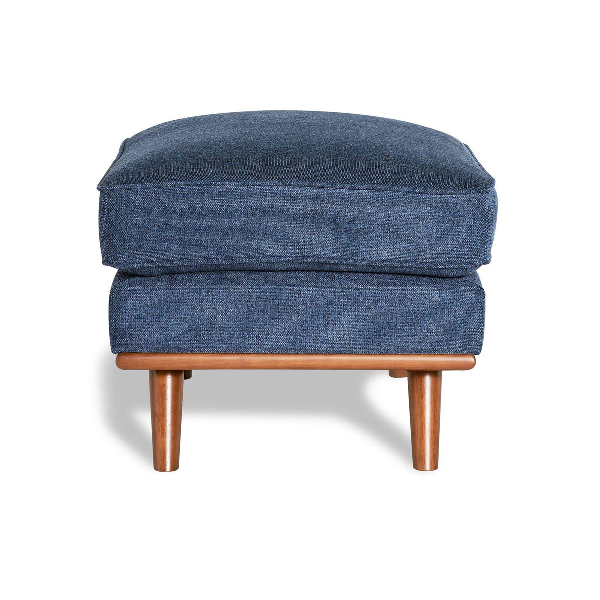 The Maddox Ottoman features a rectangular cushion in blue upholstery and rests elegantly on wooden legs, casting a shadow against a white background—ideal for adding mid-century charm to any living space.