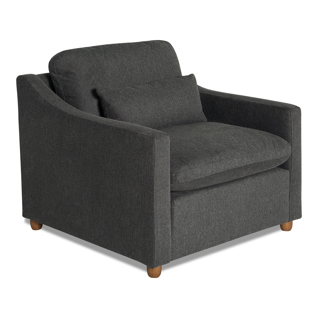The My Cloud Slope Chair, with its dark gray modern design and wooden legs, epitomizes comfort and style. Featuring a plush build and matching lumbar cushion, its slightly curved armrests enhance the inviting appeal for a true My Cloud relaxation experience.