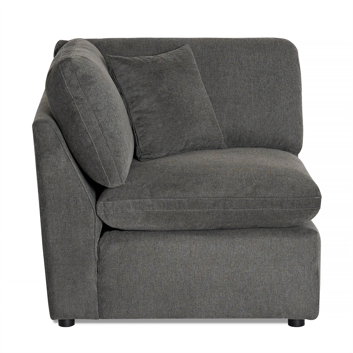 The My Cloud Slope Corner offers a versatile modular design with a dark gray plush L-shaped sectional piece. It includes a matching throw pillow against the upholstered backrest and sits on short, subtle legs. The soft, comfortable fabric makes it an inviting addition to any room.