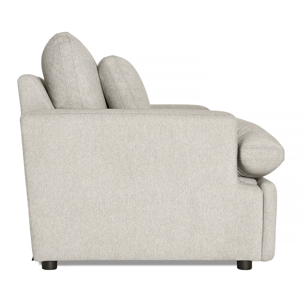 Side view of the My Cloud Power Recliner in light gray, featuring thick cushions and a low backrest. This modern piece of comfortable furniture is supported by short black legs, with soft, textured fabric for an inviting feel—perfect for relaxation in any living space.