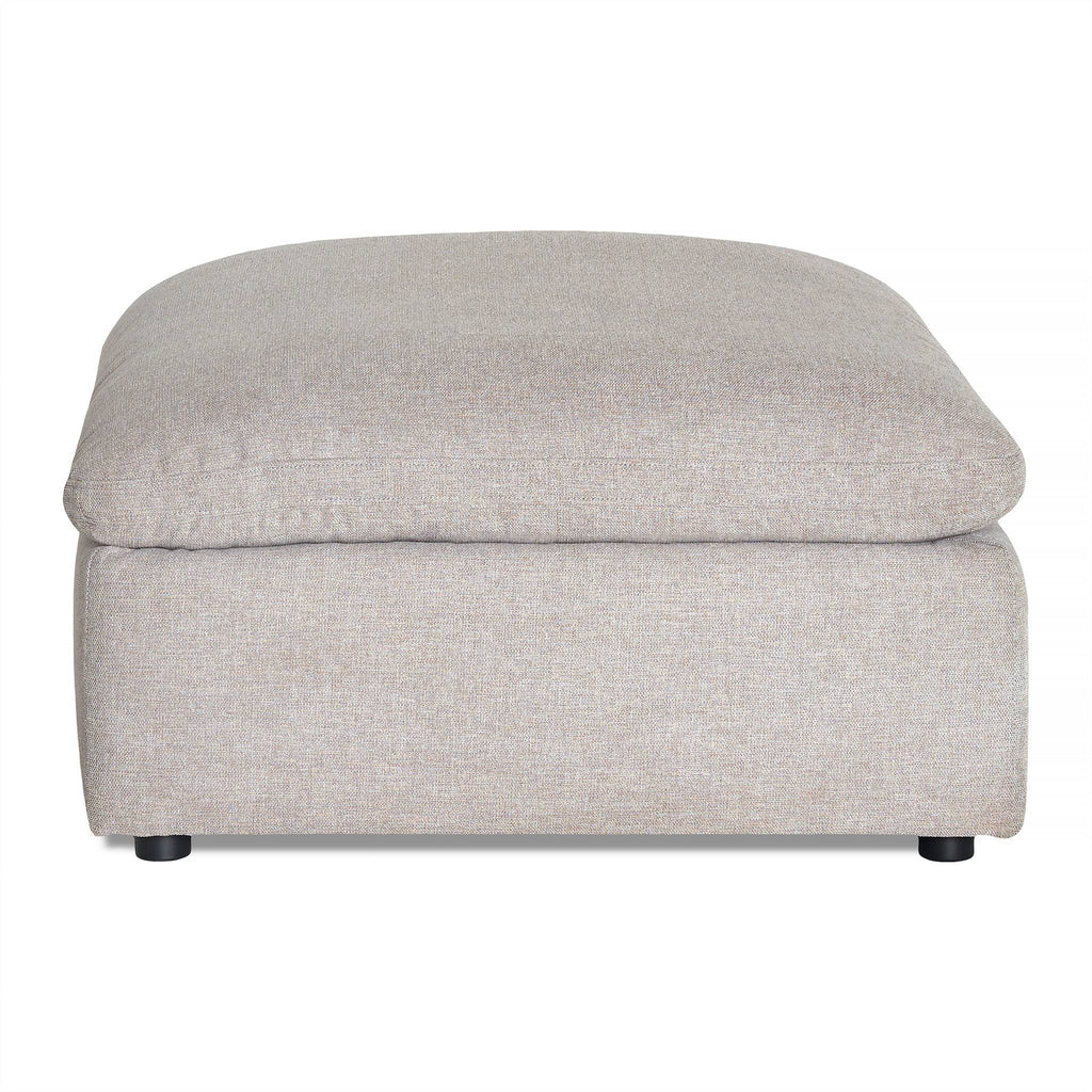 The My Cloud Slope 40 Ottoman showcases a beige upholstery with a cushioned top. Its simple, modern rectangular design and small black feet make it a comfortable, stylish addition to your customizable furniture collection.