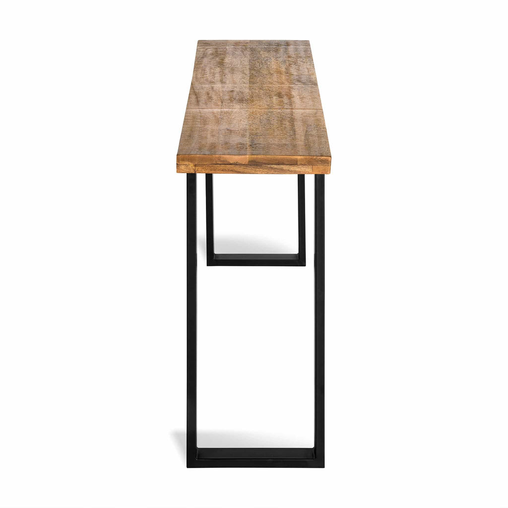 The Mango Console is a stylish wooden table with a natural finish, perfect for dining rooms. It features a rectangular mango wood top and black metal legs in a geometric design, showcasing its minimalist and modern aesthetic with an eco-friendly touch.
