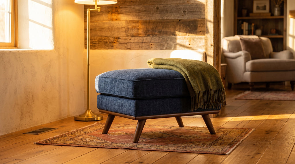 Maddox Ottoman in navy staged in a warm cozy rustic living room
