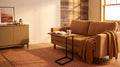 Live edge C-table sliding under a caramel sofa in a warm rustic living room with a terracotta rug