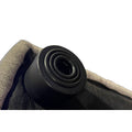 Close-up of a black cylindrical rubber Feet stopper on the edge of a textured gray-black fabric object, featuring a spiral pattern on top and surrounded by padded material.