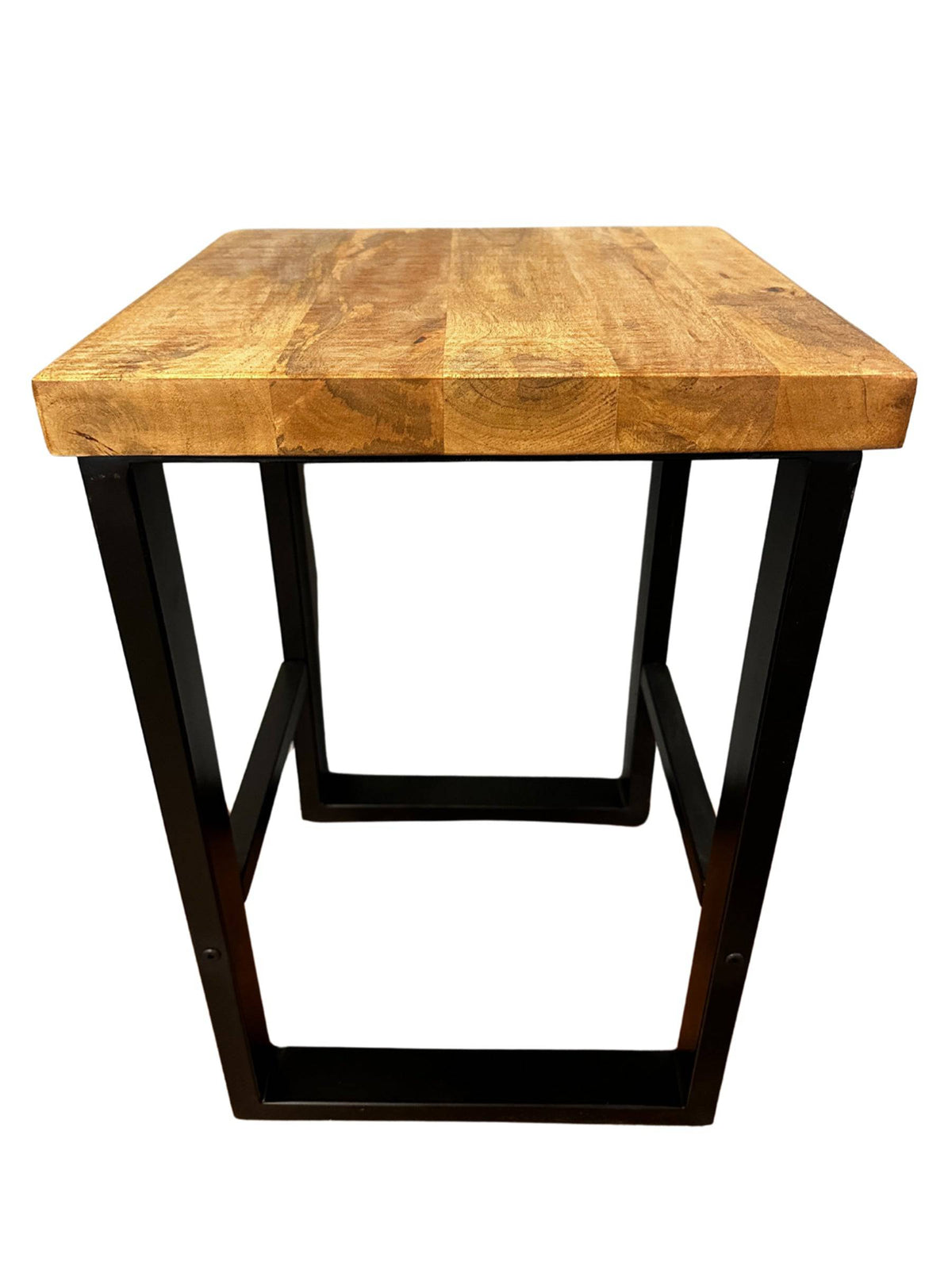 The Mango Stool is a minimalist accent piece featuring a square top made of sustainable mango wood with black metal legs in a trapezoidal frame, showcasing an industrial style.