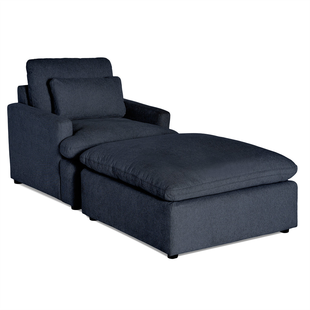 The My Cloud Chair is a customizable, dark gray cushioned chaise lounge with a high backrest, armrests, and an extended lower section for leg support, ensuring comfortable seating.